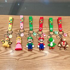 nintendo keychains are lined up on a table with mario, luigi and other characters