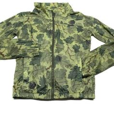 NIKE women's packable running jacket size: medium print: leaf print camo  color: Green  100% ripstop nylon Packable protection lightweight fit that packs away into a pocket  Mock neck that zips up to the chin  Pockets at chest, sides and back for multiple storage options Elastic cuffs and hem for a snug fit waterproof and breathable Underarm to underarm 20" Collar to bottom 23" R180 Military Style Nylon Windbreaker For Outdoor, Military Style Spring Windbreaker For Outdoor, Military Style Windbreaker For Spring Outdoor Activities, Spring Military Style Windbreaker For Outdoor Activities, Spring Military Windbreaker For Outdoor Activities, Nike Nylon Windbreaker For Outdoor, Fall Green Nylon Windbreaker, Green Nylon Windbreaker For Fall, Lightweight Casual Windbreaker For Hiking