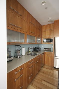 a kitchen with wooden cabinets and stainless steel appliances on the counter top, along with hardwood flooring