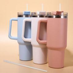 three different colored coffee mugs sitting next to each other on top of a table