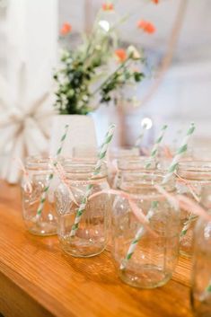 there are many mason jars with straws in them on the table next to each other