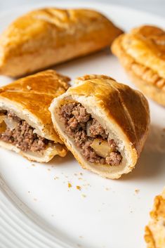 some meat and cheese pastries on a white plate