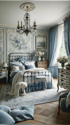 a bedroom decorated in blue and white with a chandelier hanging from the ceiling