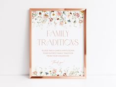 a pink frame with flowers on it and the words family traditionss written in gold