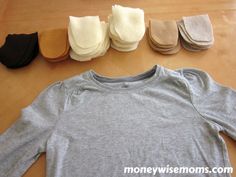 several pairs of shoes are laid out on the floor next to an unisex t - shirt