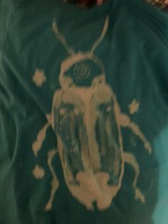 a person wearing a green shirt with a bug on it