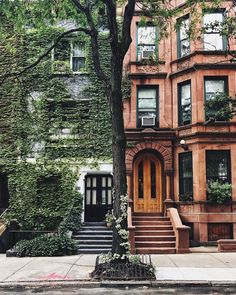 an apartment building with ivy growing on it's side and stairs leading up to the front door