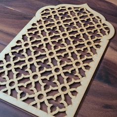 a wooden cutting board with an intricate design on it's side, sitting on a wood table