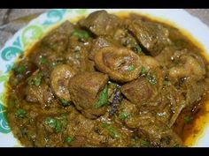 a white plate topped with meat covered in gravy and garnished with parsley