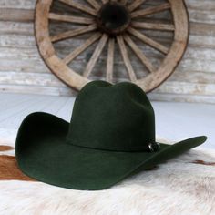 Introducing the Pine Cowboy Hat by Serratelli Hat Company, a genuine American-made accessory tailored for the modern cowgirl or cowboy. Crafted from 2X wool with a 4.25-inch brim and long oval crown, it offers both style and comfort. The satin lining and leather sweatband ensure a luxurious feel, making it the perfect blend of fashion and function. Elevate your western-inspired look with this chic and versatile piece. 4 1/4" Brim 4 3/16" Crown Color: Pine 2X Wool Made in the USA Long Oval Beaded Hat Bands, Modern Cowgirl, Kids Belt, Beaded Hat, Feather Hat, Outdoor Hats, Boy Hat, Leather Hats, Green Wool