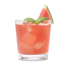 a watermelon drink with mint and lime garnish in a glass on a white background