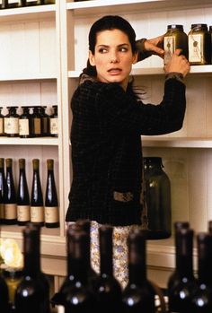 a woman standing in front of shelves filled with bottles