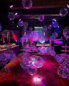 a room filled with lots of clear balls floating in the air over a wooden floor