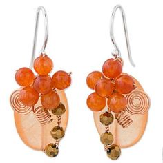 A lush flower garden blooms with light and deep orange hues as these earrings bring a bouquet of natural beauty to your outfit. Thai artist Nareerat crafts these dangle earrings from dyed oval quartz and glass beads. Twisted copper wire adds additional detail to each piece. The earrings hang from sterling silver hooks. Elegant Orange Jewelry For Spring, Elegant Orange Spring Jewelry, Spring Orange Drop Earrings, Orange Drop Earrings For Spring, Orange Earrings For Spring Gift, Bohemian Orange Earrings For Spring, Spring Gift Orange Earrings, Orange Dangle Jewelry For Spring, Bohemian Orange Jewelry For Spring