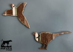 two wooden birds are hanging on the wall