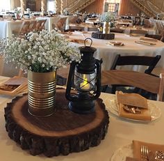 there is a vase with flowers in it on top of a wooden slice at the table