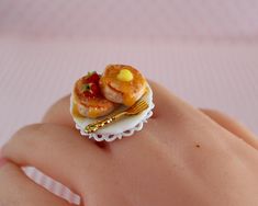 there is a miniature food ring on top of someone's hand with a fork