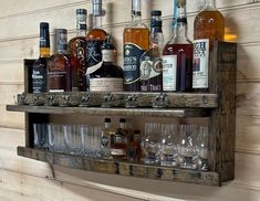 several bottles and glasses are lined up on a shelf