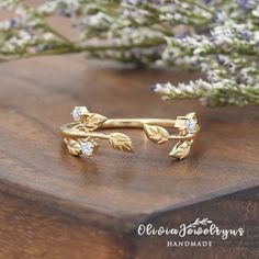 a close up of a ring on a wooden surface with flowers in the back ground