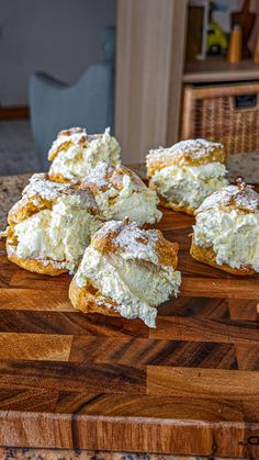 several pastries on a cutting board with powdered sugar