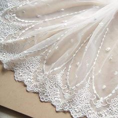 the white lace is laying on top of a piece of paper