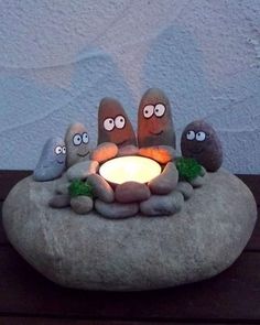 some kind of rock with eyes on it and a lit candle in the shape of three rocks