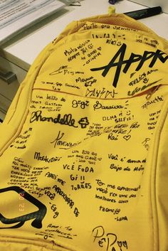 a yellow backpack with writing all over it