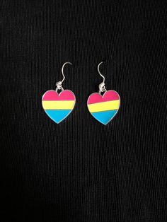 These pansexual heart hanging earrings are pink, yellow and blue striped heart charms on a silver-plated ear wire. Earrings are approximately 5/8 inch by 5/8 inch. Copper or iron are the base materials for the wires. Pansexual Outfits, Striped Heart, Pride Heart, Pansexual Pride, Out Of The Closet, Hanging Earrings, Yellow And Blue, Wire Earrings, Earrings Photo