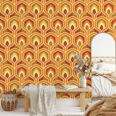 an orange and yellow wallpaper in a bedroom with a mirror on the side table