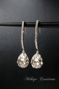 a pair of diamond earrings hanging from a hook