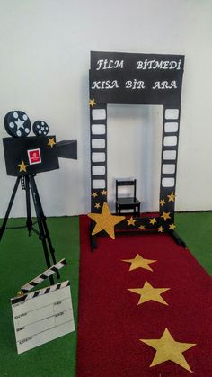 a red carpet with yellow stars on it next to a black and white movie camera