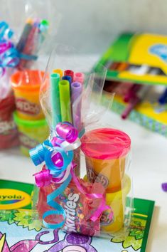 there are many different colored markers and pens in the cup on top of this table