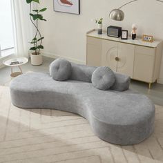 a large gray couch sitting on top of a white rug