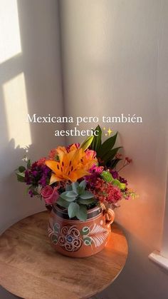 a flower pot sitting on top of a wooden table next to a window with the words mexicana pero tambien aesthetic