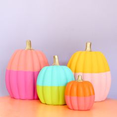 three different colored pumpkins sitting next to each other