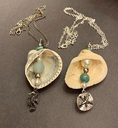 two seashells with charms on them sitting next to each other