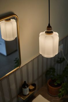 a bathroom sink with a mirror and two lights hanging from it's side wall