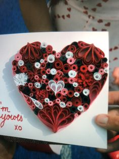 someone is holding up a valentine's card made out of yarn and paper flowers