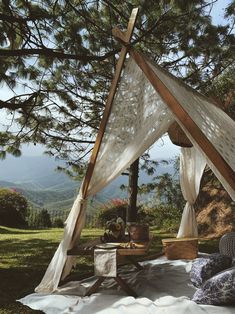 a bed sitting under a tree in the middle of a field