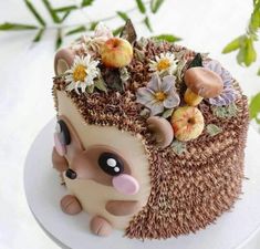 a hedgehog cake is decorated with flowers and leaves