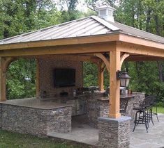 a covered patio with an outdoor kitchen and bar