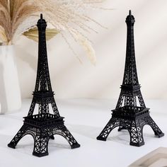 two small black metal eiffel tower sculptures