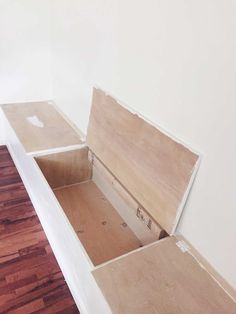 an open box sitting on top of a hard wood floor next to a white wall