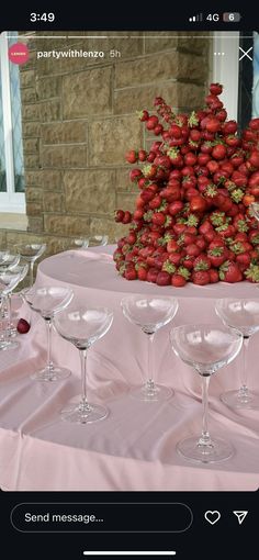 there are many wine glasses on the table with strawberries in them, and one is empty