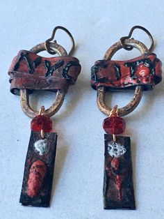 New York New York! Copper enamel dangle earrings featuring unique connectors created by Andrea from JosephineBeads, copper wrapped and with the handpainted letters NYC CITY, from which hang faceted ruby red Czech glass rondelles and abstract copper, handpainted strips. One of a kind. Earrings hang 5.5cm from vintaj ear wires. Artistic Red Jewelry For Jewelry Making, Artistic Red Enamel Jewelry, Hand Painted Metal Dangle Jewelry, Hand Painted Red Dangle Jewelry, Red Hand-painted Dangle Jewelry, Handmade Artsy Red Jewelry, Artisan Red Copper Earrings, Red Hand Painted Dangle Jewelry, Artsy Handmade Red Jewelry