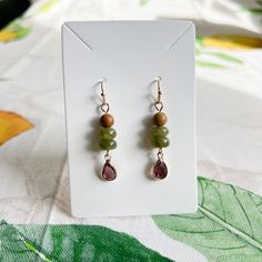 Gold Dangle Earrings Feature Wood Beads, Wine Ruby Garnet Red Crystal Glass Teardrops, Forest Moss Colored Deep Green Jade Beads And French Ball Ear Hooks. Also Available As A Set Approximately 2 Inch Drop Earrings Come With Silicone Stoppers Ships Within 2 Business Days Customization Available Made To Order Made With Love And Care Wine Ruby Garnet Red Crystal Forest Moss Green Jade Wood Bead Casual Earrings / Boho, Western, Dainty, Every Day, Daily Wear, Nature Earrings, Natural Stone, Beads, A Crystal Forest, Forest Moss, Bead Dangle Earrings, Earthy Jewelry, Glass Bead Earrings, Casual Earrings, Garnet Red, Nature Earrings, Gold Dangle Earrings