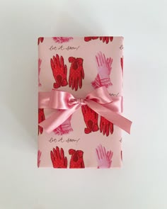 a pink wrapping paper with red gloves on it