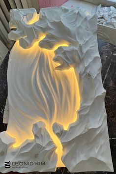 a white sculpture with yellow lights on it