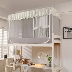 a white bunk bed with curtains on the top and ladders down to the bottom