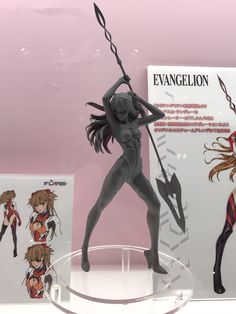 a plastic figurine is displayed in front of an advertisement for evangelion